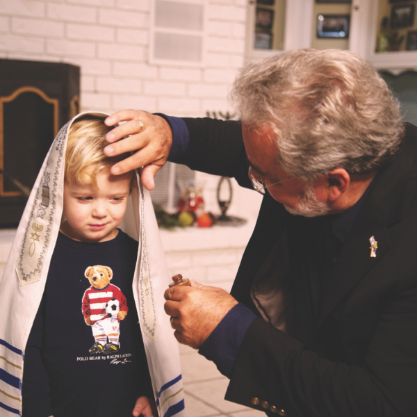 Rabbi anointing young boy with Holy Kings Oil