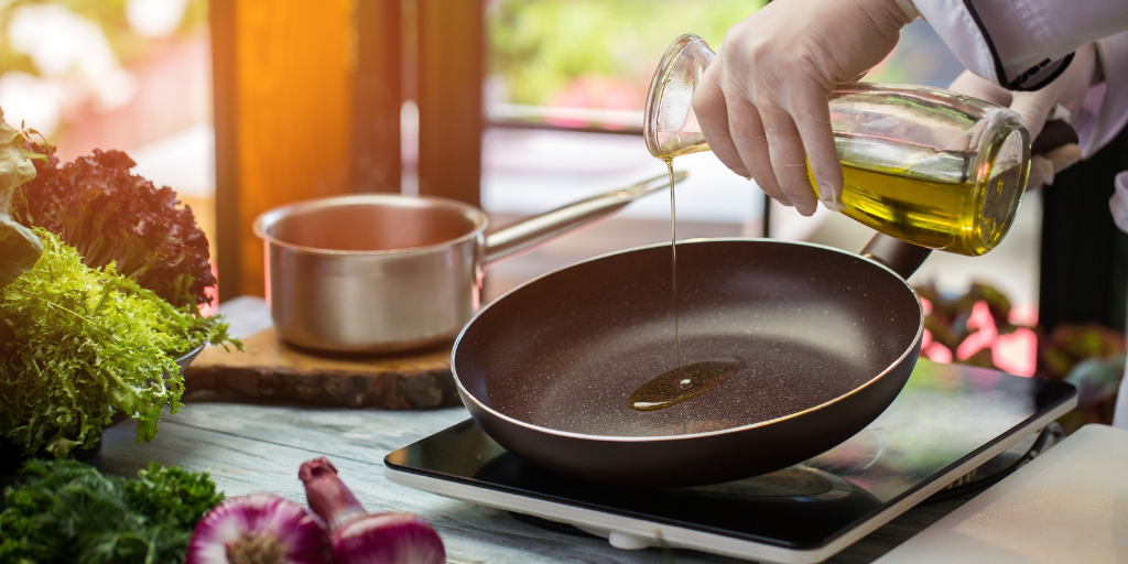 Olive oil being poured into a pan getting ready to cook dishes.