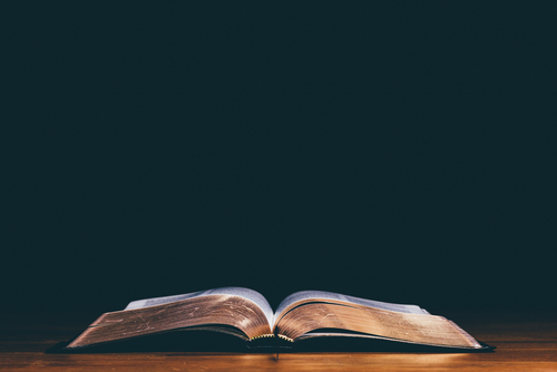 Open bible and black background