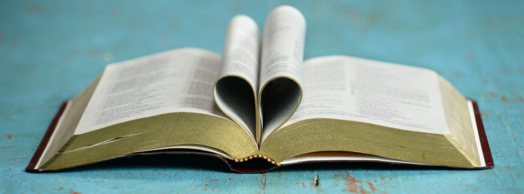 bible opened with middle pages folded in to make a heart