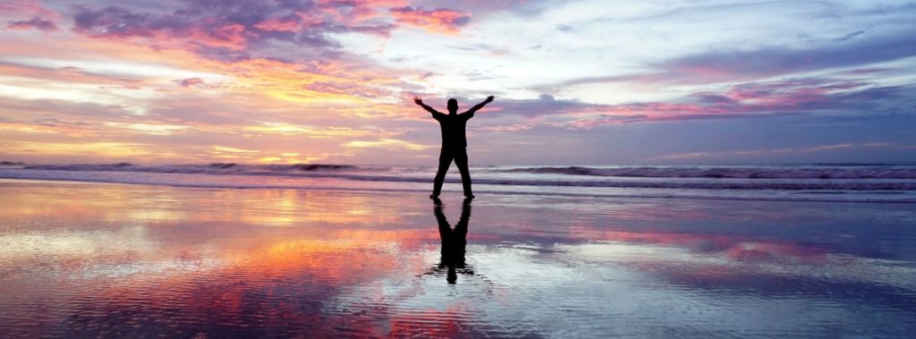 Man standing on beach appreciating his body as a temple of the Lord.