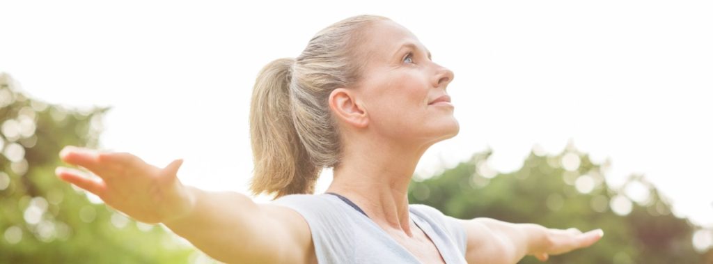 Woman exercising outside achieving balance of physical, spiritual, and emotional health.