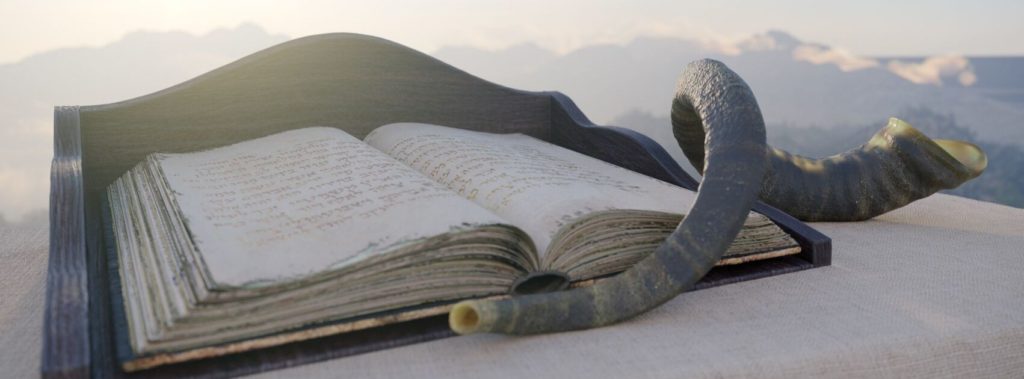 Shofar and ancient religious text on top of mountain, examples of Jewish artifacts.