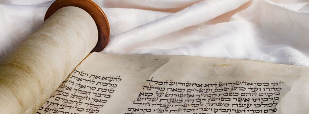Torah resting on white cloth.