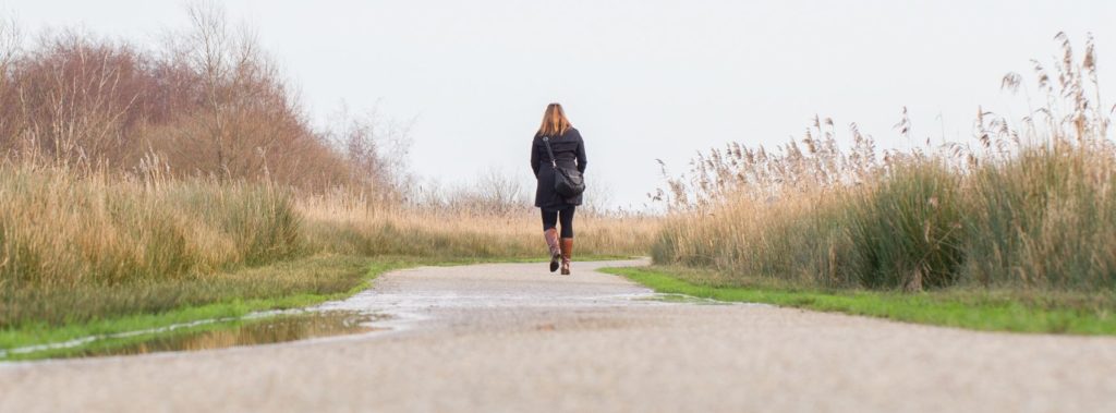 Woman walking down country road in honor and humility.