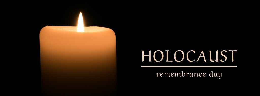 Holocaust Remembrance Day written on black background next to a lit candle.