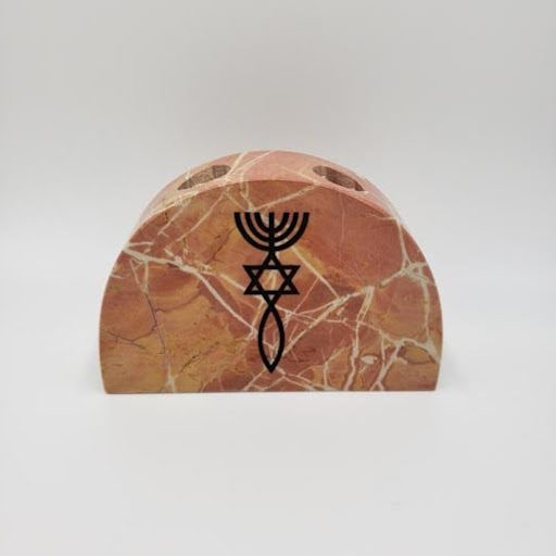 A close up of the Jerusalem stone candle holder with the One New Man symbol etched on