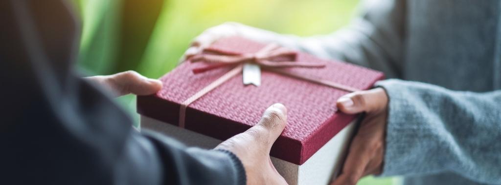 Close-up of man handing a gift box to a woman as concept for finding and giving hope.