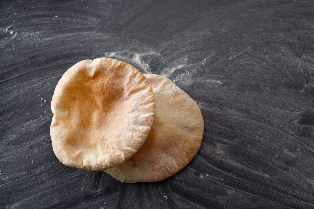 Pita bread on a floured surface made from the perfect pita recipe